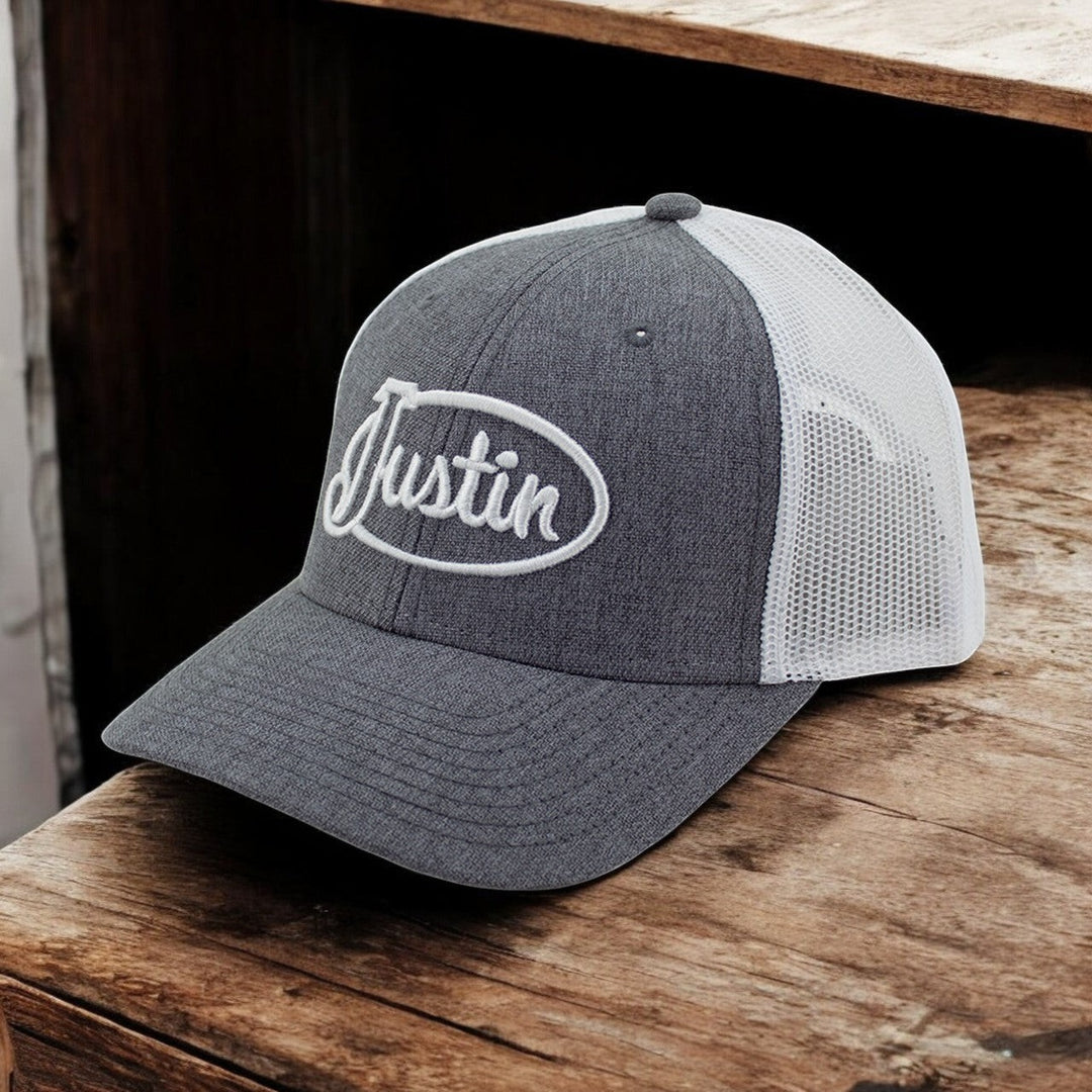 Justin Boots México gray trucker cap with white mesh back and embroidered logo. Adjustable snapback closure.